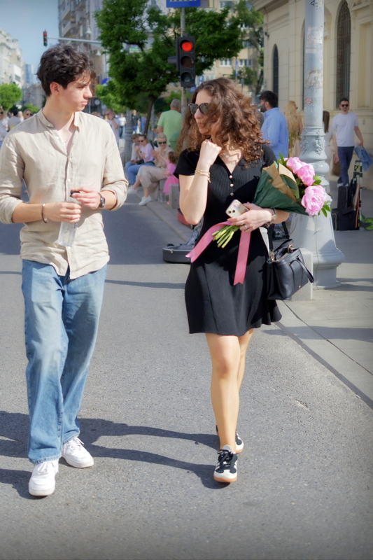 A couple strolling on a cobblestone street in Bucharest